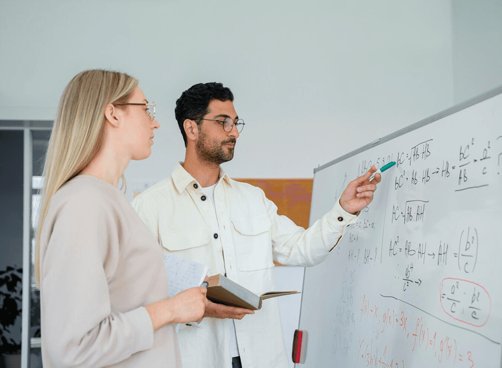 Teacher explaining math on board
